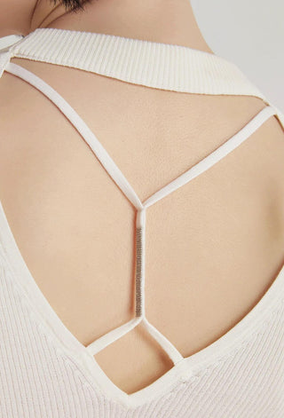 Close-up of white open-back crisscross straps with V-shaped strap lines
