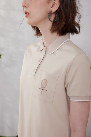 Camel polo dress neckline with collar trim and embroidered racket on chest pocket.
