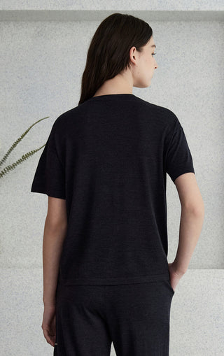 Black hooded zip knit cardigan from back view; full-length hood and dropped shoulders.