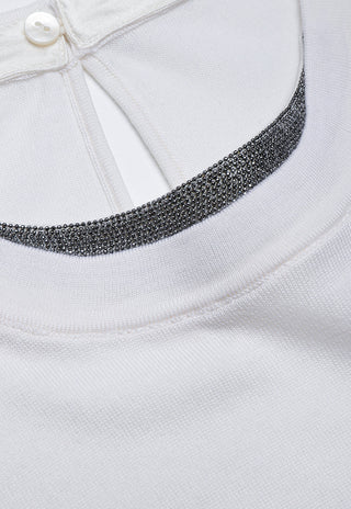 Close-up of white sheer knit beaded neckline trim with small round top button