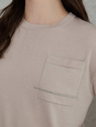 Close-up of beige knit top chest pocket with subtle beaded stripe detail
