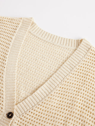 Light beige cardigan sleeve close-up with ribbed knit band and dark button