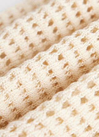 Light beige openwork linen knit texture with visible stitch pattern and holes