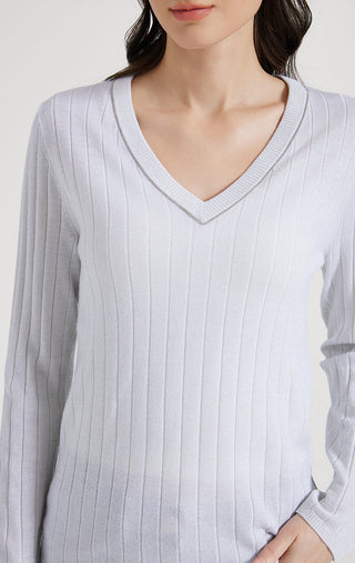 Close-up of white V-neck ribbed knit top with long sleeves and neckline edging