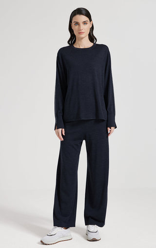 Dark knit top with crew neck and long sleeves, slightly cropped hem