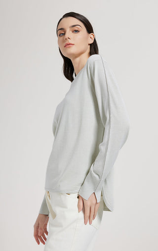Sage green knit top with crew neck and long sleeves, side profile