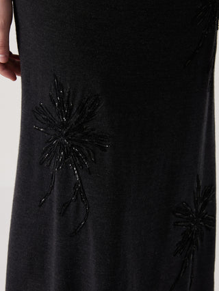 Close-up of black skirt with detailed starburst flower embroidery