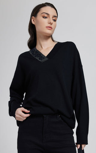 Black V-neck knit top with subtle beading at neckline, long sleeves