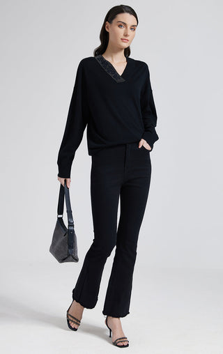 Black wool-silk knit top with beaded V-neck and long sleeves, worn with dark pants