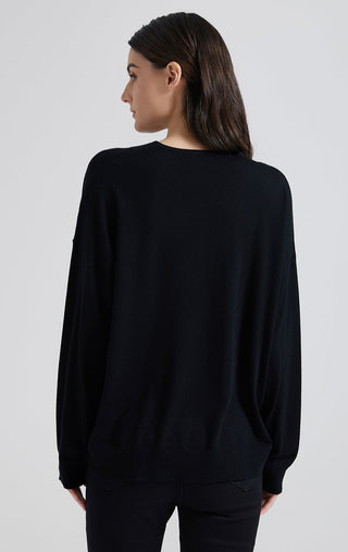 Back view of black V-neck knit top with long sleeves and relaxed straight hem