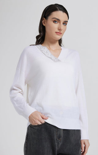 White wool-silk V-neck knit top with beaded neckline and long sleeves, worn front view