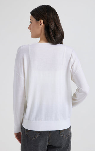 Back view of white V-neck knit top with long sleeves and straight hem