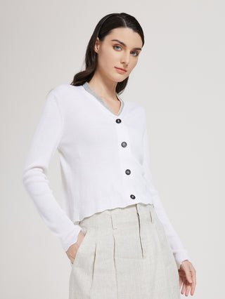 White cardigan sweater with button-front, V-neck trim, and hip-length ribbed cuffs