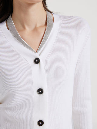 Close-up: white cardigan neckline with gray-trim V and round black buttons
