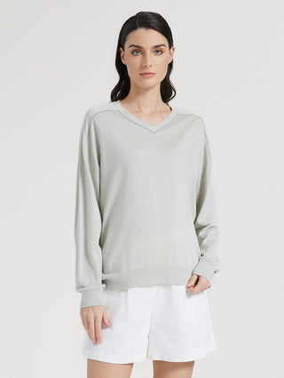 Sage green knit top with long sleeves and V-neck beaded trim detail