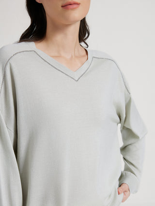 Sage green knit top with V-neck beaded trim along the neckline edge