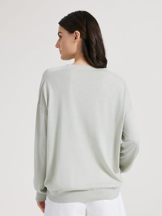 Sage green knit top back view with long sleeves and V-neck collar