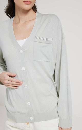 Sage green cardigan closeup: beaded neckline trim, button placket, chest pocket