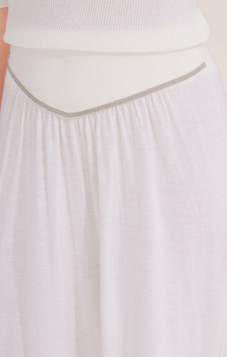 Close-up of white wool midi skirt waistband with beaded chain trim detail