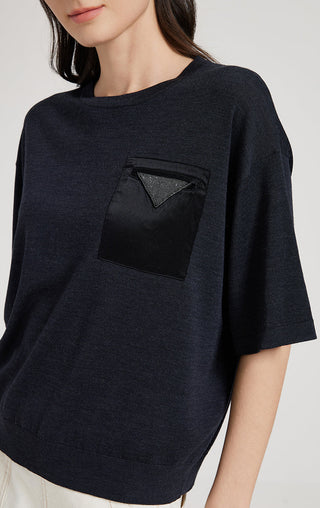 Dark gray knit T-shirt close-up of front patch pocket with triangular embellishment