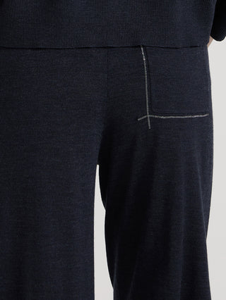 Dark gray knit pants with contrast-stitched seam detail at the hip