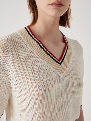 Close-up of cream ribbed knit V-neck top with striped neckline trim and red/black edge