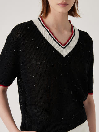 Close-up of black ribbed knit V-neck top with striped trim and sequin-speckled surface