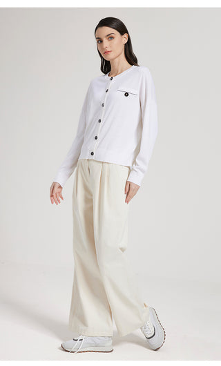White wool silk knit cardigan with button closure and stand collar, paired with trousers
