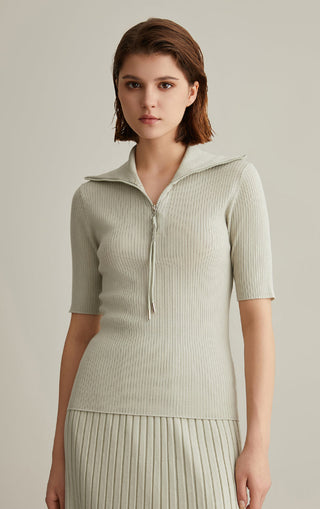 Olive green wool-silk knit top with short sleeves, ribbed texture, and half-zip mock neck