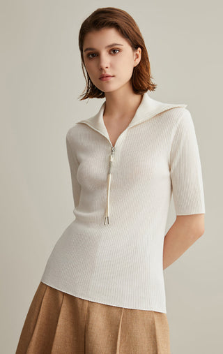 Ivory white ribbed knit top with zipped mock neck, short sleeves, and tassel drawcord