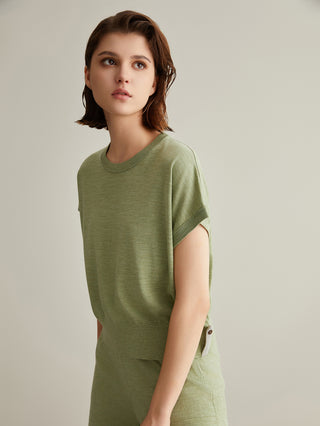 Green knit short-sleeve top, crew neck; side tab opening visible at waist