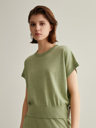 Green wool-silk knit top with short sleeves and crew neck; layered waist seam