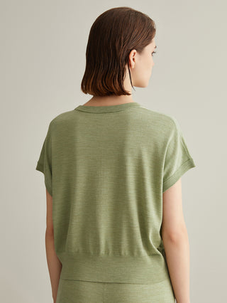 Green knit top from back view; short sleeves with relaxed drape and seam