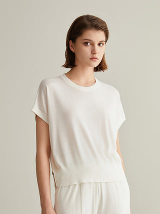 White short-sleeve knit top with crew neck; layered waistline detail