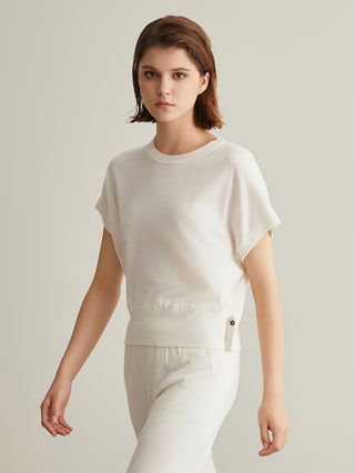 White knit top with crew neck and short sleeves; beaded side tab at hip