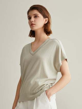 Sage green silk-wool V-neck top with short sleeves and gathered waist hem