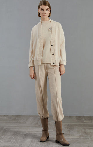Beige cashmere V-neck button cardigan worn open over top; ribbed collar and cuffs