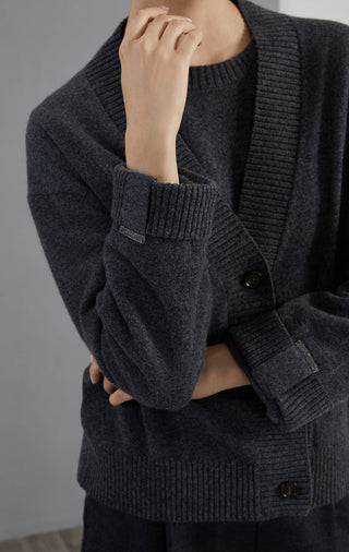 Dark gray cashmere cardigan sleeve and front buttons close-up with ribbed cuffs