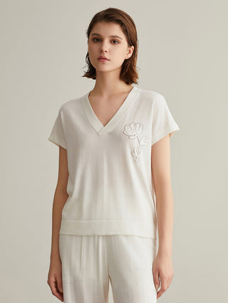 White wool-silk knit top with V-neck, short sleeves, and white-on-white floral embroidery