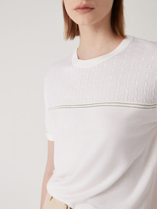 White textured knit top front close-up with cable pattern and ribbed hem