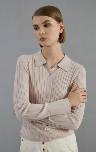 Pale taupe ribbed knit cardigan with collared button-front; arms crossed close-up