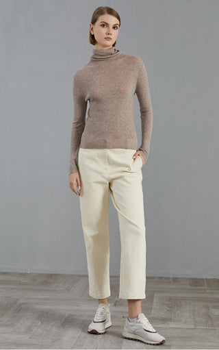 Dark camel ribbed turtleneck top paired with light trousers, long sleeve