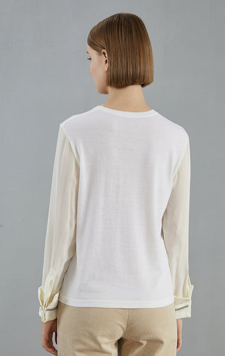White knit pullover back view with crew neck; beaded cuff trim at wrists.