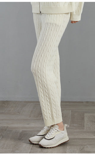 White wool cable-knit pants with vertical cable pattern and ribbed ankle cuffs
