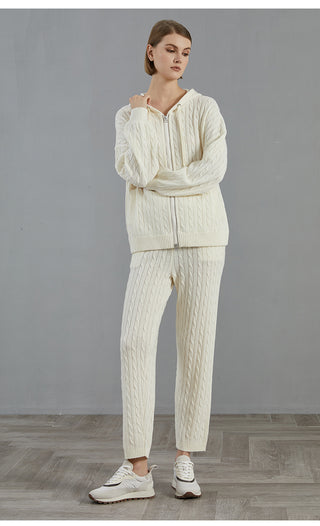 White cable-knit wide-leg pants with vertical cable texture and ribbed cuffs
