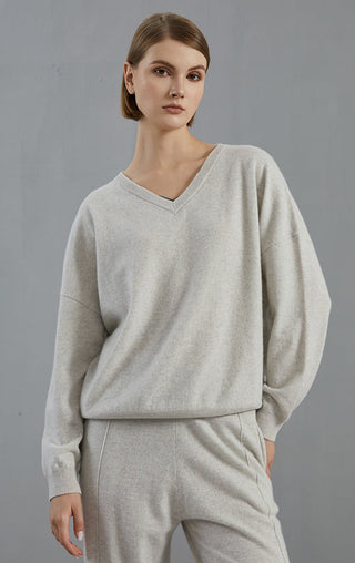 Light gray cashmere v-neck sweater with layered neckline detail and long sleeves