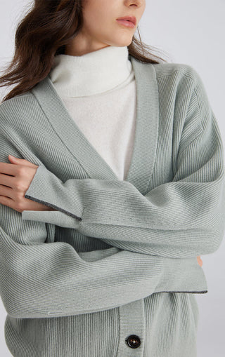 Light green wool ribbed button cardigan close-up: long sleeves and single dark button