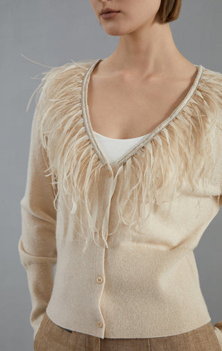 Apricot feather-trim cardigan close-up: V-neck edging, button front, long sleeves