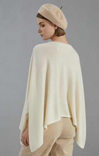 Back view of white cashmere oversized poncho sweater with cape drape and textured knit