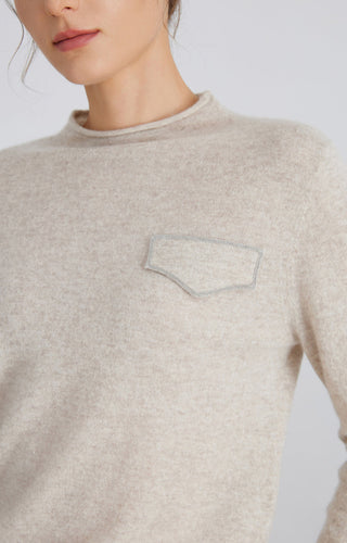 Light gray cashmere top close-up: embroidered silver chain pocket detail at chest